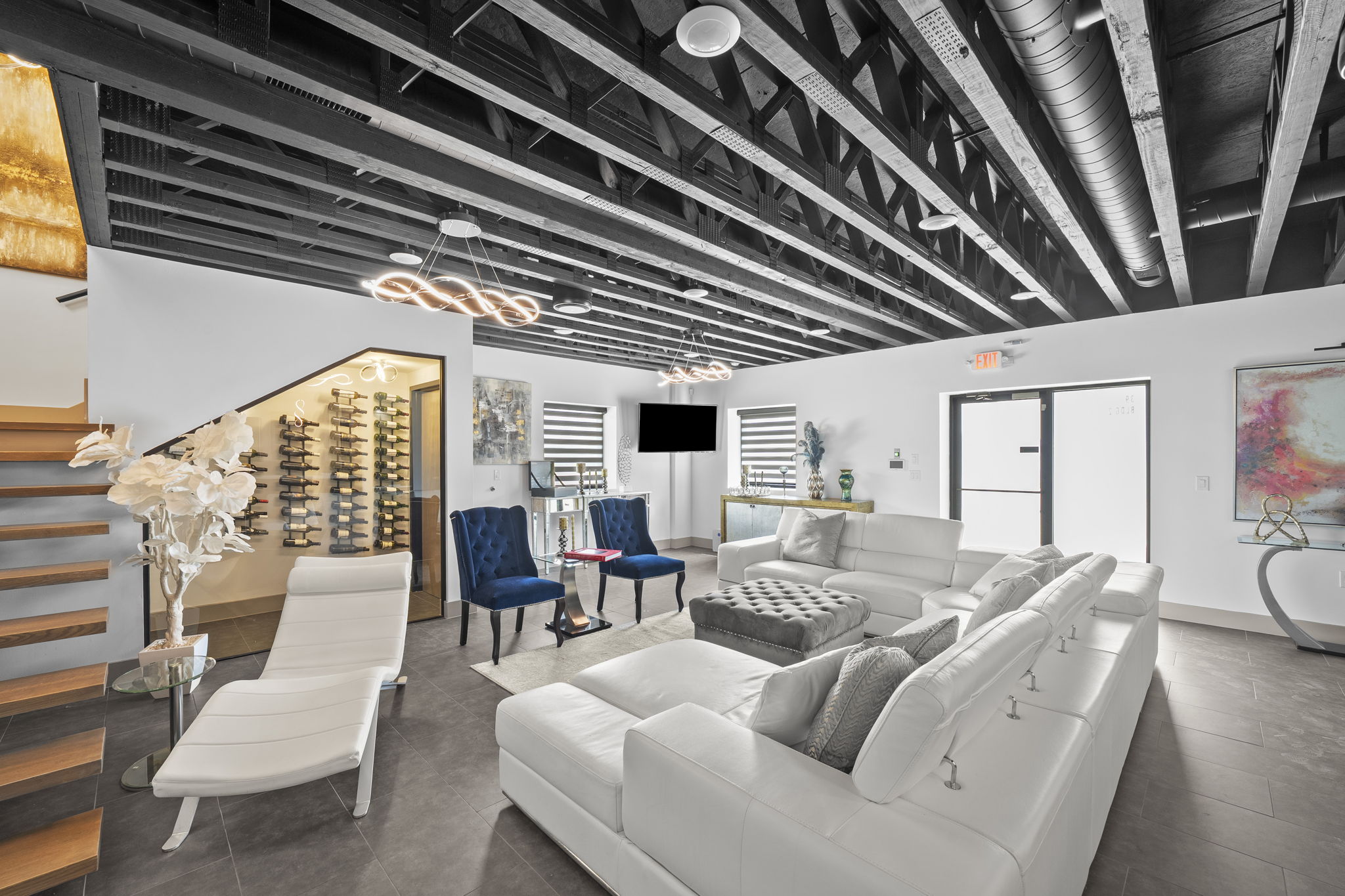 Ultimate man cave lounge with full bar, wine wall, and floating staircase